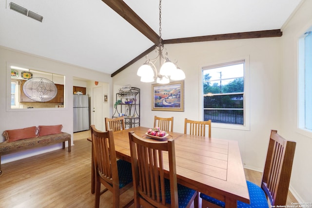 dining area featuring lofted ceiling with beams, a healthy amount of sunlight, hardwood / wood-style flooring, and an inviting chandelier