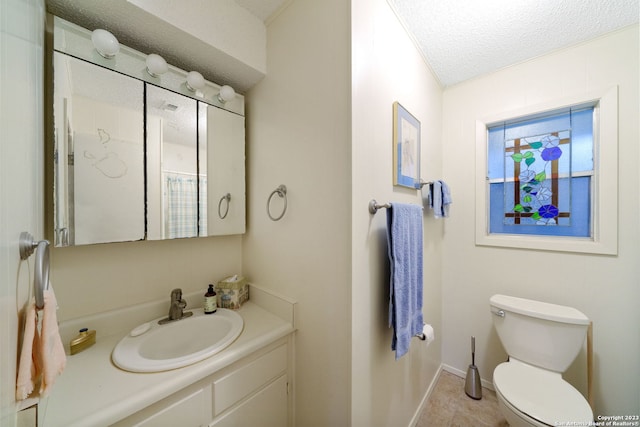 bathroom with tile patterned flooring, toilet, crown molding, vanity, and a textured ceiling