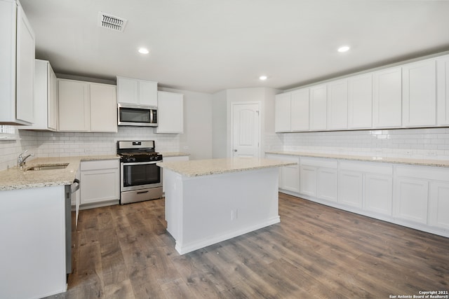 kitchen with appliances with stainless steel finishes, dark wood-type flooring, sink, and white cabinets