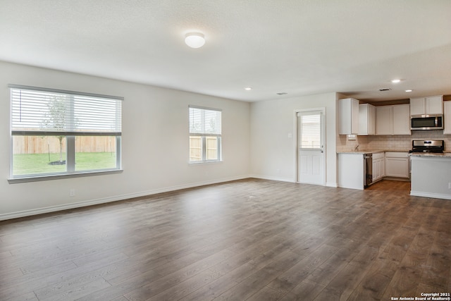 unfurnished living room featuring hardwood / wood-style floors and a healthy amount of sunlight