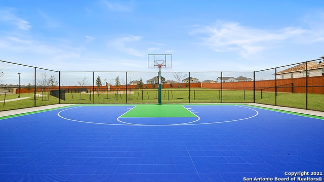 view of basketball court with a yard