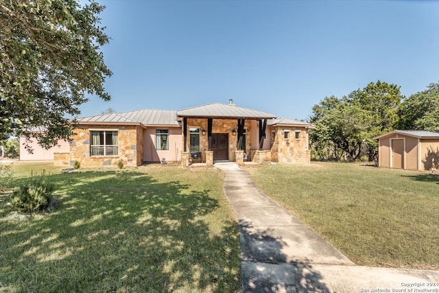 view of front of home featuring a front yard and a storage unit