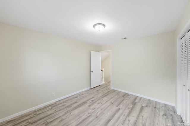 unfurnished bedroom with light wood-type flooring and a closet