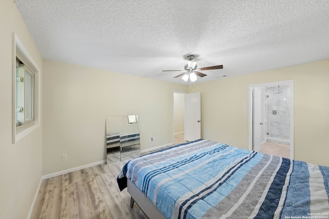 bedroom with ceiling fan, a textured ceiling, light wood-type flooring, and connected bathroom