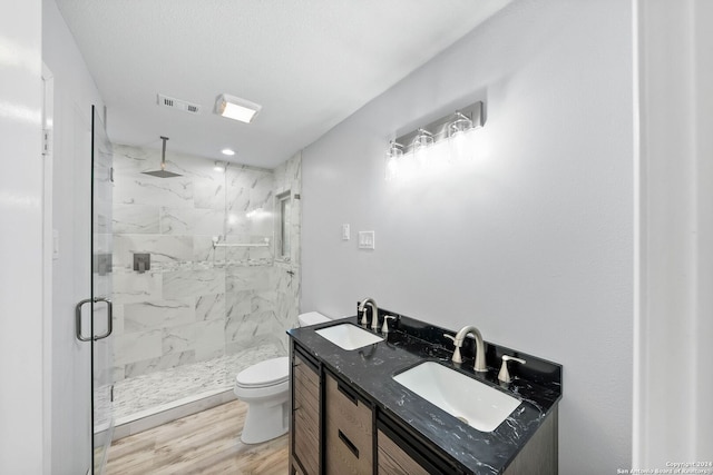 bathroom featuring wood-type flooring, vanity, toilet, and an enclosed shower