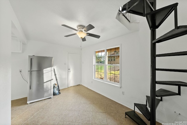 unfurnished living room featuring light tile patterned floors and ceiling fan