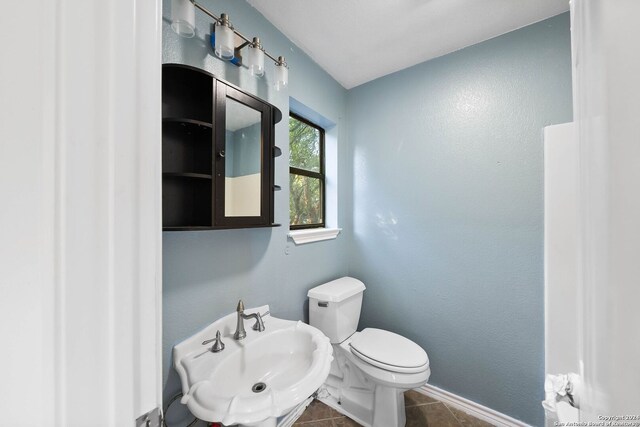 bathroom with sink, tile patterned flooring, and toilet