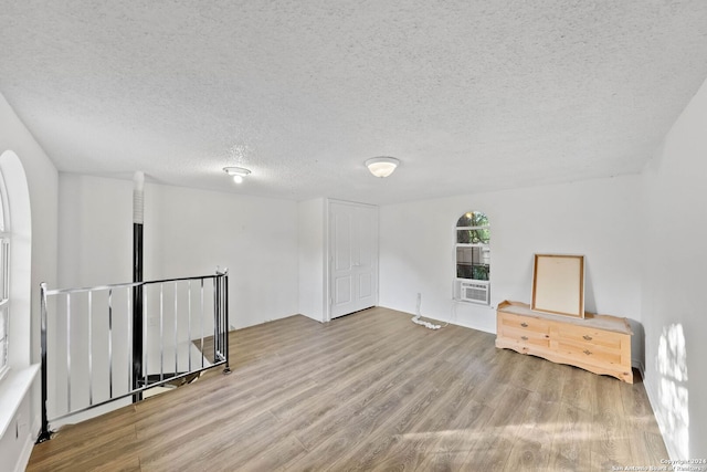 empty room with a textured ceiling and light wood-type flooring