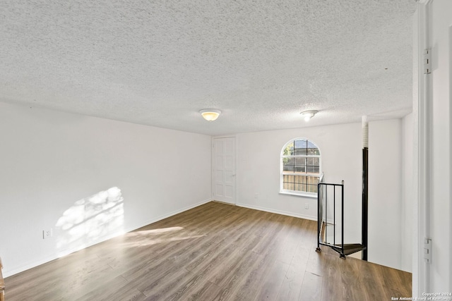 unfurnished room featuring a textured ceiling and hardwood / wood-style floors