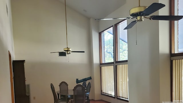 interior space featuring a towering ceiling and ceiling fan