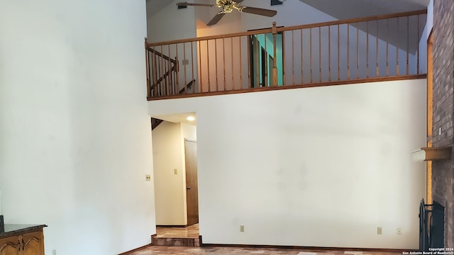 interior space with a towering ceiling, hardwood / wood-style flooring, and ceiling fan