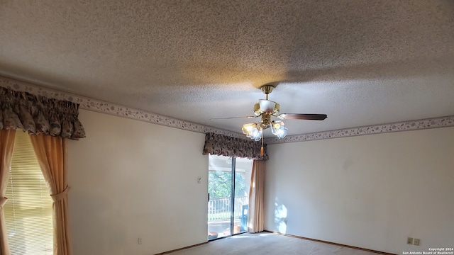 empty room with a textured ceiling and ceiling fan