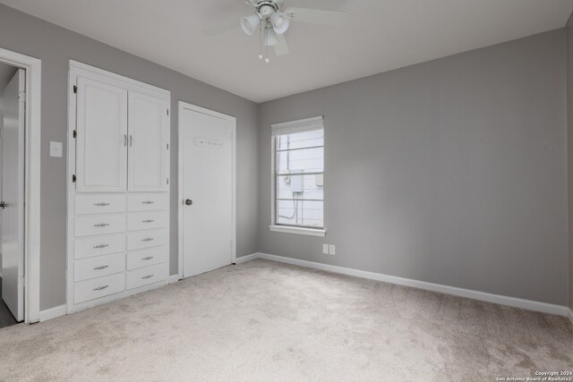 unfurnished bedroom featuring ceiling fan and light colored carpet