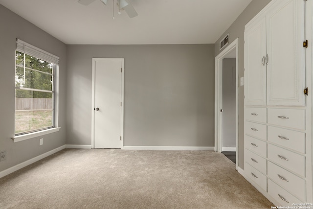 unfurnished bedroom with ceiling fan, light colored carpet, and multiple windows