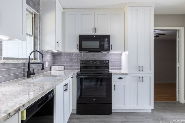 kitchen with sink, white cabinets, and black appliances