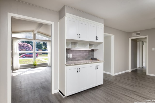 kitchen featuring dark hardwood / wood-style flooring, backsplash, and white cabinets