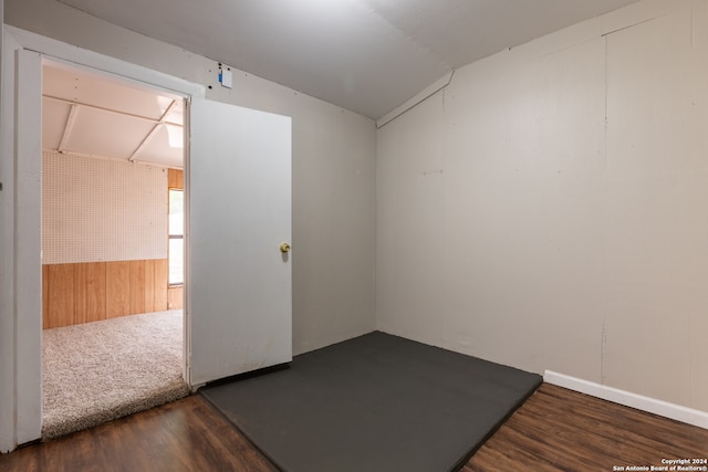 unfurnished room with dark wood-type flooring and lofted ceiling