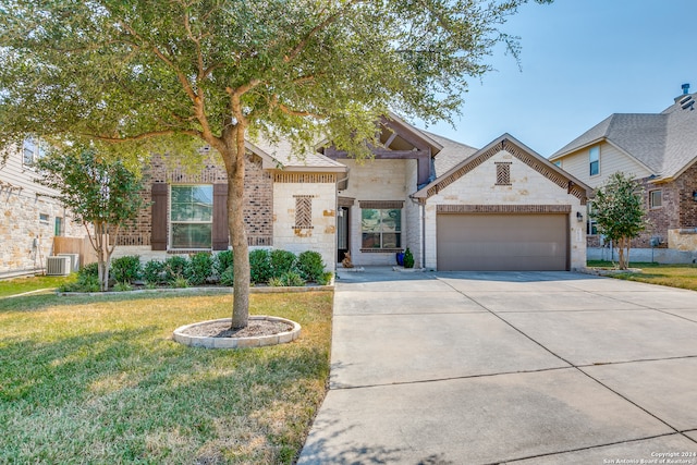 view of front of house featuring a garage, a front yard, and central AC unit