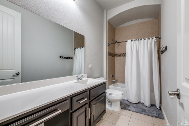 full bathroom with tile patterned flooring, toilet, shower / tub combo with curtain, vanity, and a textured ceiling