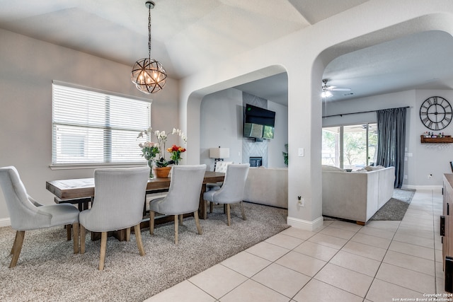 tiled dining area featuring ceiling fan with notable chandelier