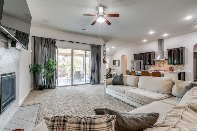 carpeted living room featuring a fireplace and ceiling fan