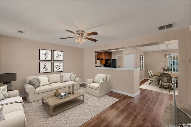 living room featuring wood-type flooring and ceiling fan