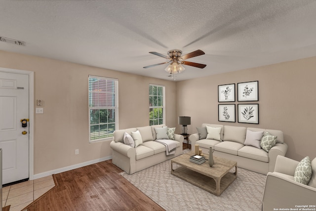 living room featuring ceiling fan, hardwood / wood-style floors, and a textured ceiling