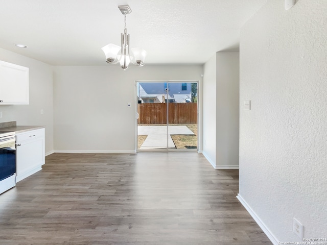 unfurnished dining area featuring hardwood / wood-style flooring and a notable chandelier