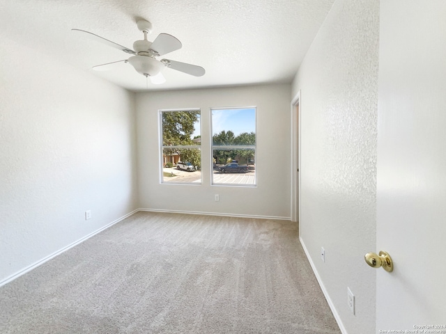 carpeted empty room featuring ceiling fan and a textured ceiling