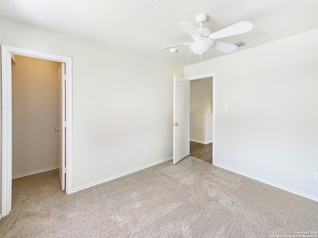 spare room featuring ceiling fan and light carpet