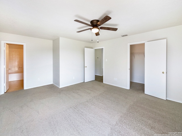 unfurnished bedroom featuring carpet floors, a closet, connected bathroom, and ceiling fan