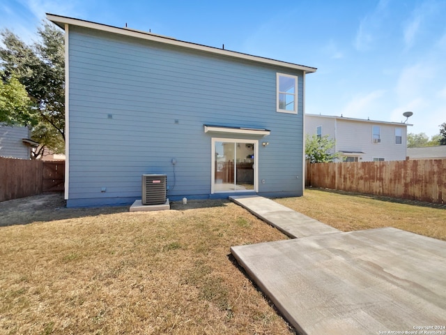 rear view of house with a lawn, a patio, and central AC