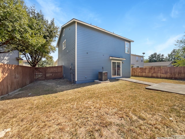 back of house with a yard, a patio area, and central AC