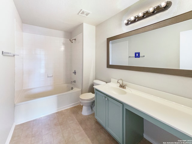 full bathroom with tiled shower / bath, vanity, and toilet