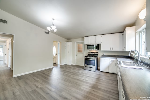 kitchen with lofted ceiling, light hardwood / wood-style flooring, sink, white cabinets, and appliances with stainless steel finishes