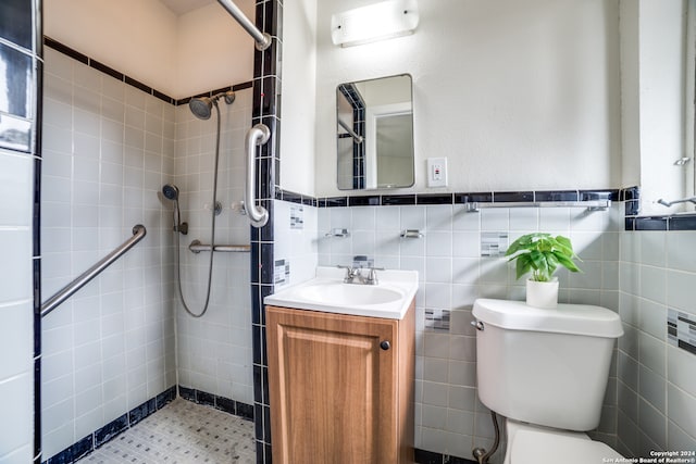 bathroom with toilet, vanity, tile walls, and tiled shower