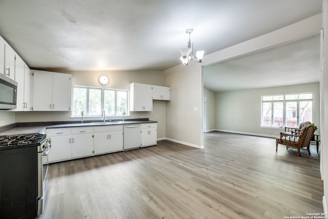 kitchen with white cabinetry, vaulted ceiling, gas range oven, dishwasher, and sink