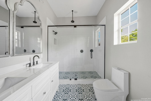 bathroom featuring vanity, a shower with shower door, and toilet