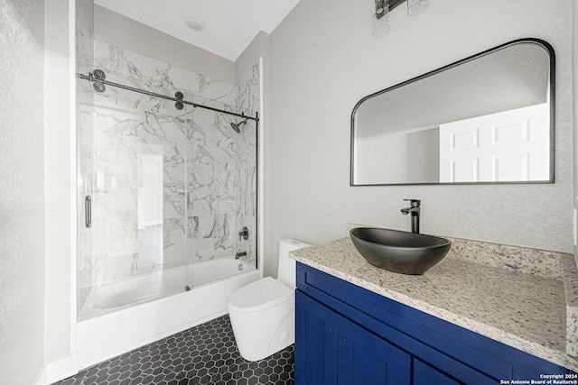 full bathroom with tile patterned floors, shower / bath combination with glass door, vanity, and toilet