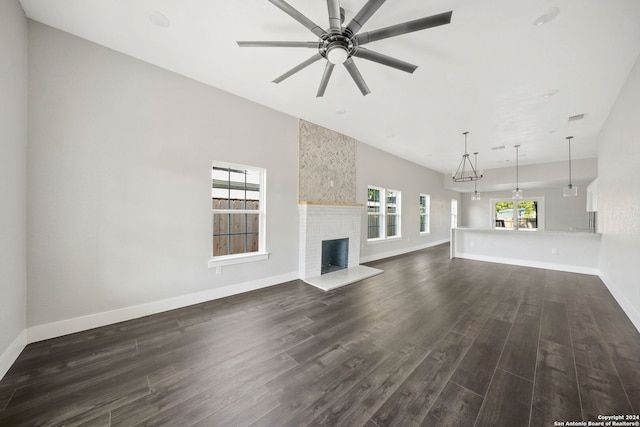 unfurnished living room featuring dark wood-type flooring, a fireplace, and ceiling fan