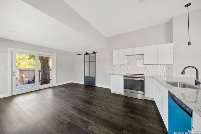 kitchen with hanging light fixtures, sink, white cabinetry, stainless steel appliances, and a barn door