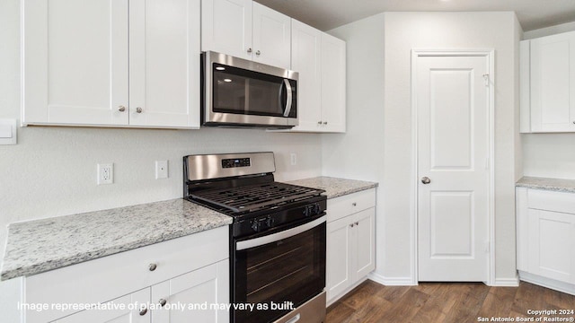 kitchen with dark wood-type flooring, light stone countertops, white cabinetry, and stainless steel appliances