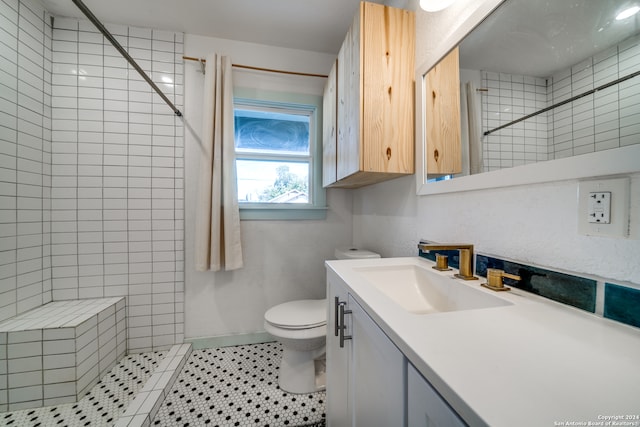 bathroom featuring tile patterned floors, vanity, tiled shower, and toilet