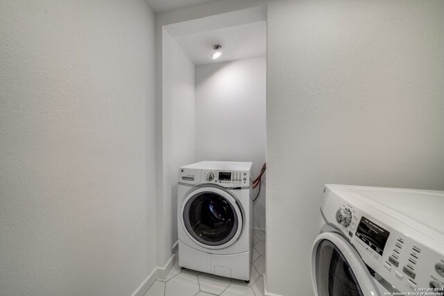 laundry area featuring washer and dryer and light tile patterned floors