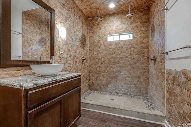 bathroom featuring a tile shower, hardwood / wood-style floors, and vanity