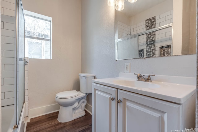 full bathroom with bath / shower combo with glass door, wood-type flooring, vanity, and toilet