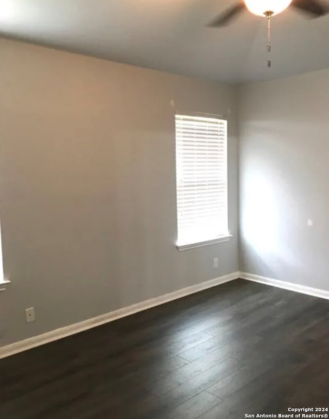 spare room featuring ceiling fan and dark wood-type flooring