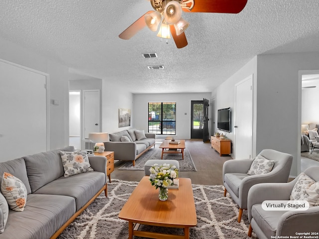 living room featuring ceiling fan, a textured ceiling, and carpet floors