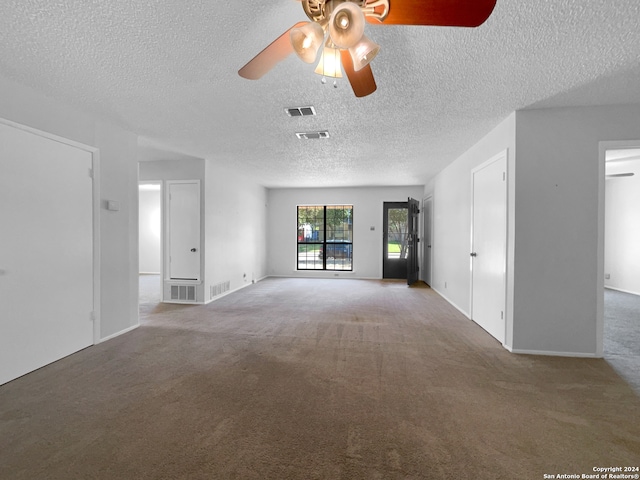 unfurnished living room featuring ceiling fan, carpet floors, and a textured ceiling