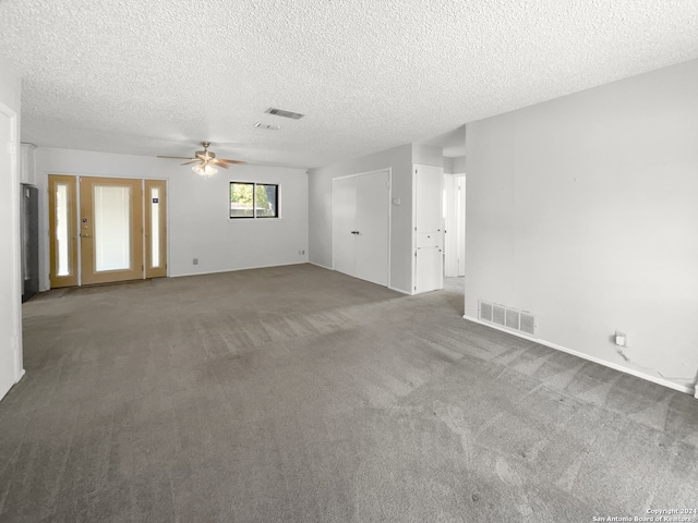 unfurnished living room featuring ceiling fan, carpet, and a textured ceiling